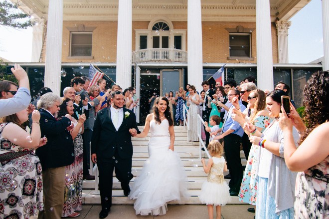 bride and groom exit the museum while guests blow bubbles-1