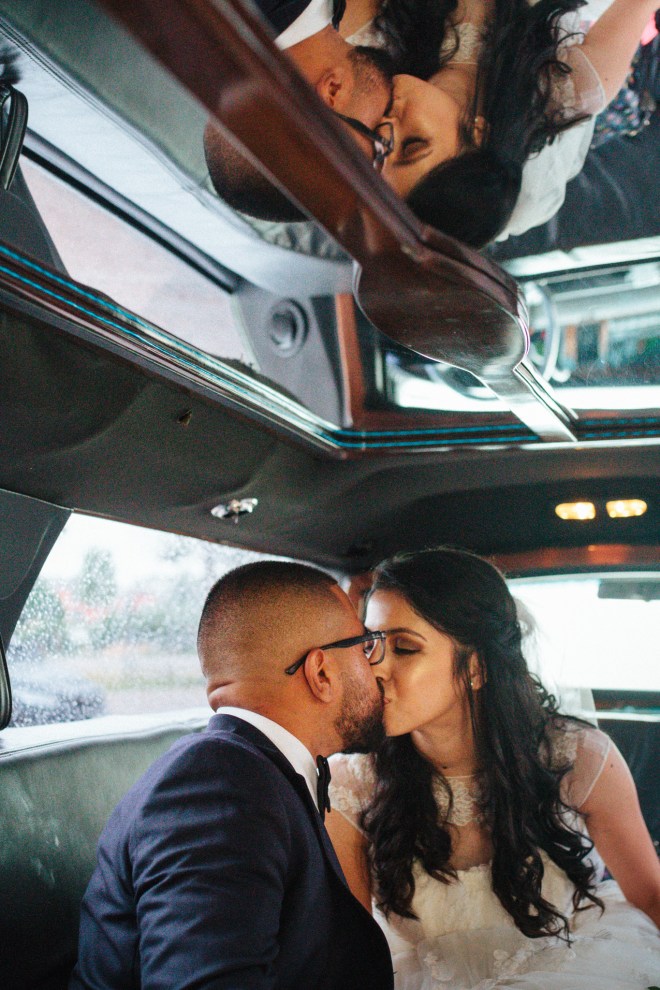 bride and groom kiss in the limo